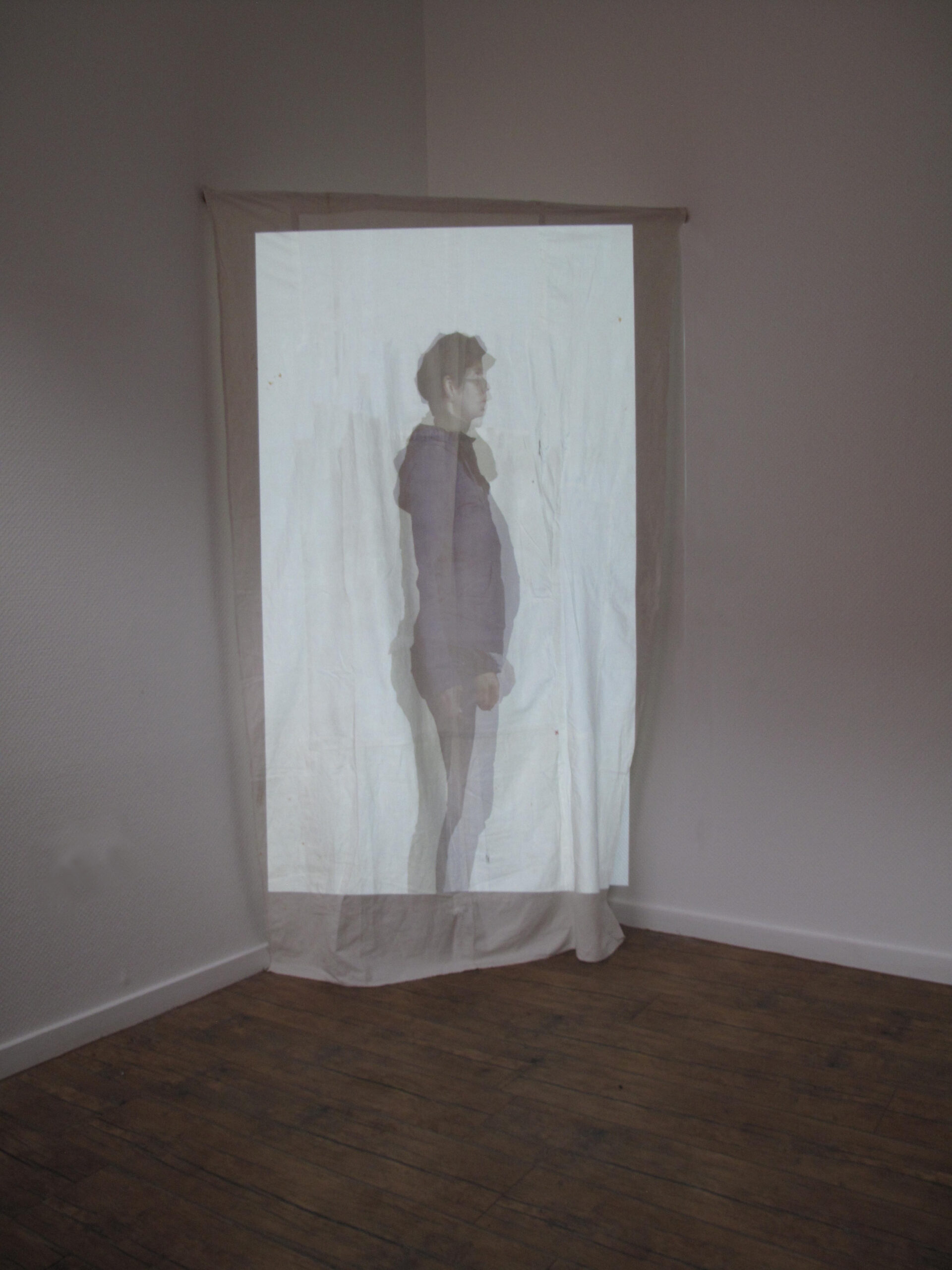Hochformatige Videoprojektion einer Person auf Bettlaken